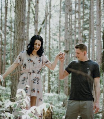 A happy couple by trees while helping each other theare going to couples therapy in Houston texasy