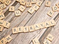 Betrayal spelled with Scrabble tiles.