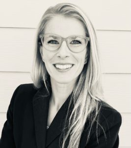 Smiling woman with glasses and long hair.