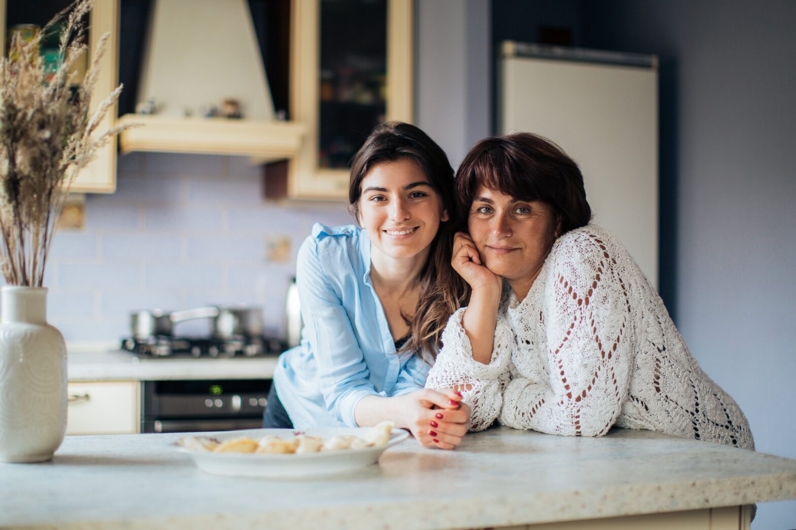 Mother and daughter smiling in kitchen.