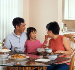 A happy family enjoys a meal together. Our therapists provide counseling for individuals, couples, and families in The Woodlands.