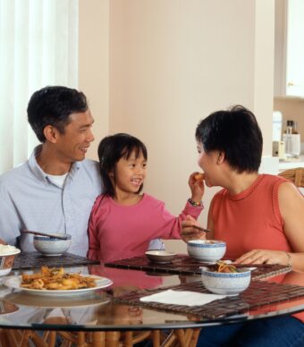 A happy family enjoys a meal together. Our therapists provide counseling for individuals, couples, and families in The Woodlands.