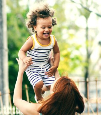 A mother holds her smiling child above her. We offer tele-therapy services in California, Florida, Louisiana, Texas, and Utah. We also offer child counseling near Houston, TX.